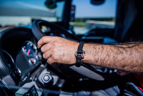 Hands of a delivery driver holding the steering wheel of a truck