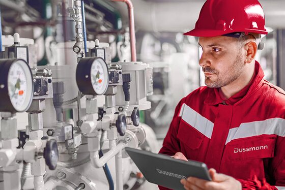 Man wearing a hard hat in an industrial mechanical environment, supervising operations