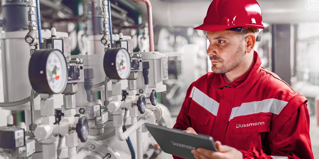 Man wearing a hard hat in an industrial mechanical environment, supervising operations