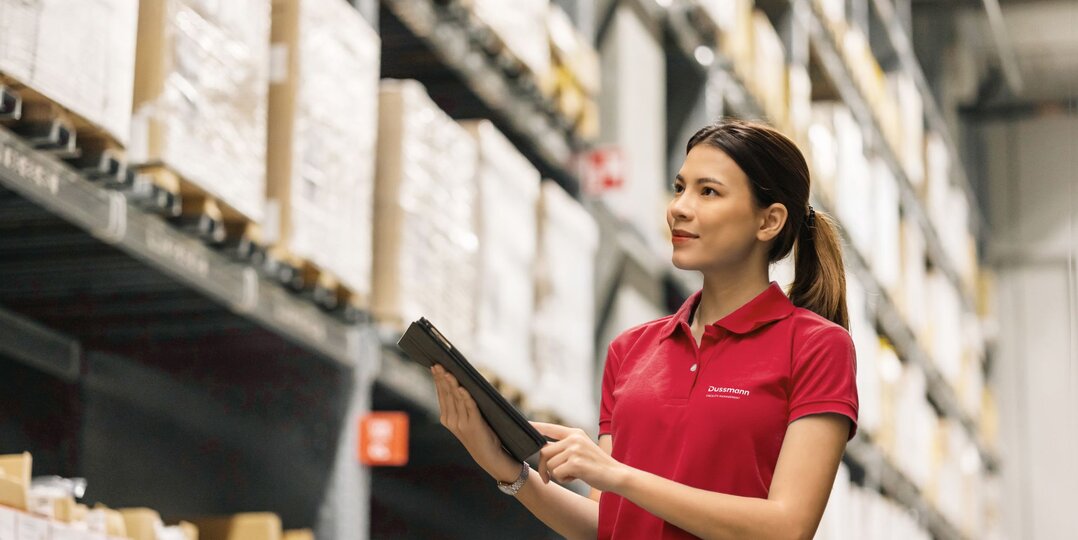 Woman in a stockroom with merchandise, using a tablet