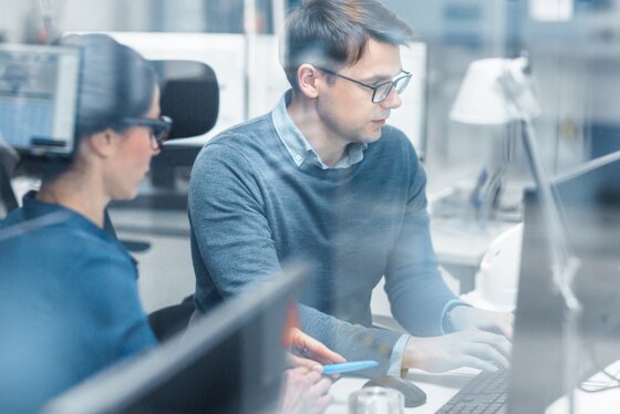 Man and woman working together on a computer in an office