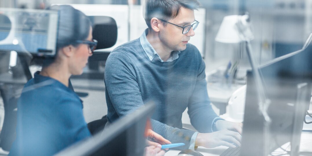 Man and woman working together on a computer in an office